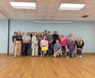 A group of people standing in front of a blue wall