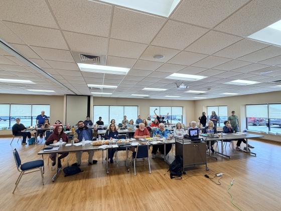 a group of individuals sitting in a classroom style setting